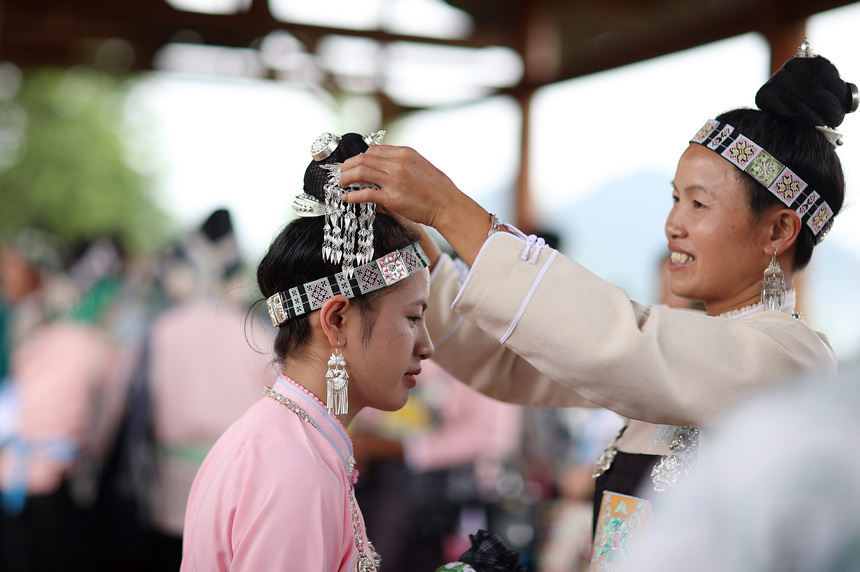 8月5日，苗族村民在爬坡節中盛裝打扮。