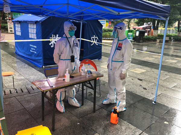 李剛（右）在執勤點和同事溝通防疫工作。貴陽市公安局云巖分局供圖