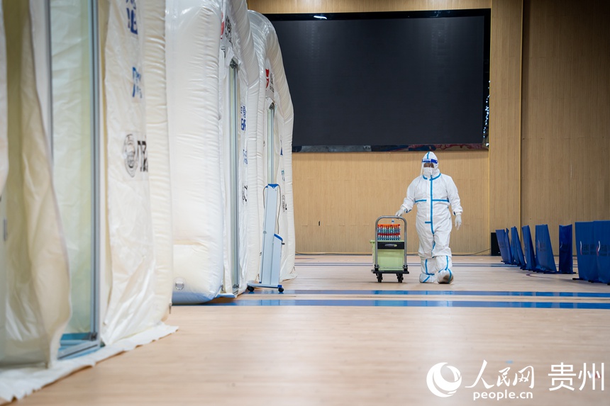 工作人員將核酸樣本送入氣膜倉。人民網 涂敏攝