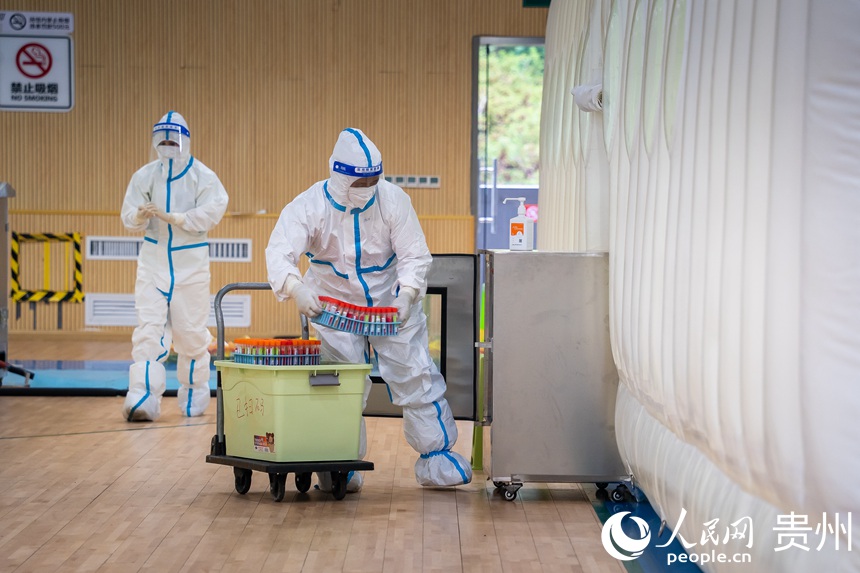 工作人員將核酸樣本送入氣膜倉。人民網 涂敏攝