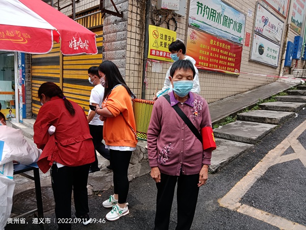 退干部張德碧堅守社區路口(右一）。
