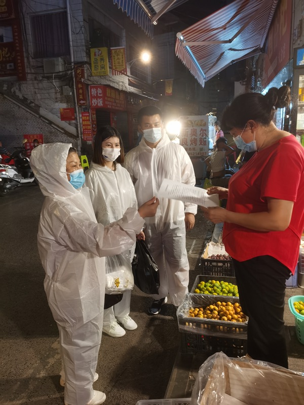 閔紅為居民介紹抗原試劑說明（左一）。