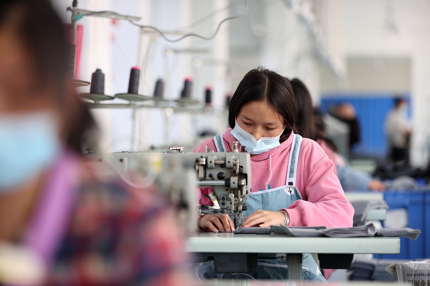 10月11日，工人在移民安置社區“幫扶車間”加工背包。