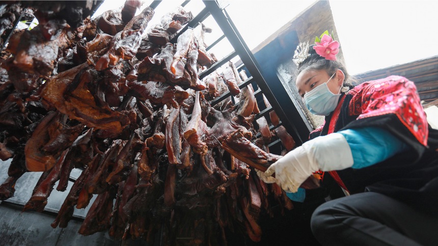 2023年1月2日，苗族群眾在查看臘肉熏制情況。