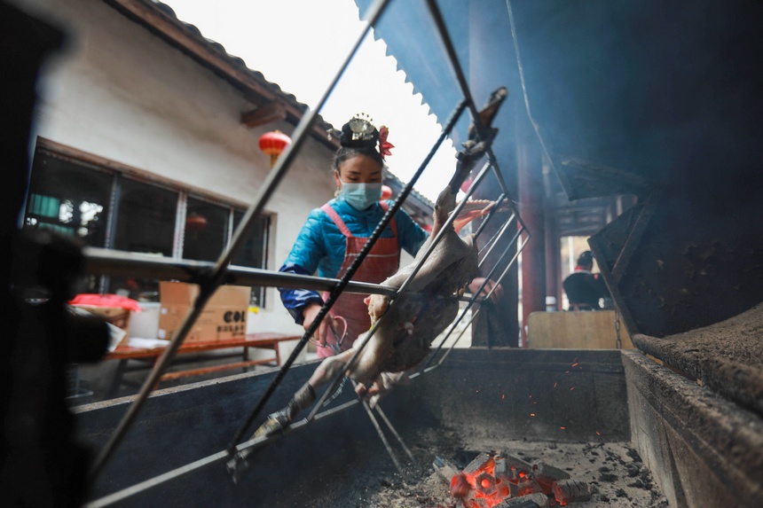 2023年1月2日，苗族群眾在烘烤板鴨。