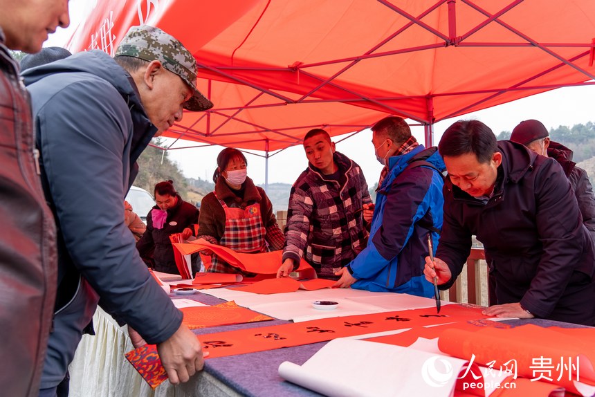 書法愛好者為村民書寫春聯。人民網 涂敏攝