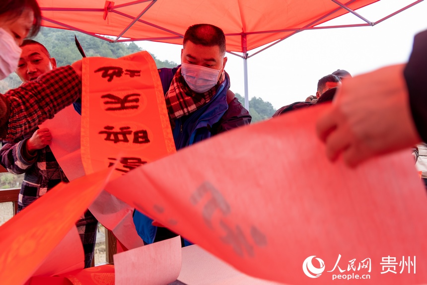 書法愛好者為村民書寫春聯。人民網 涂敏攝