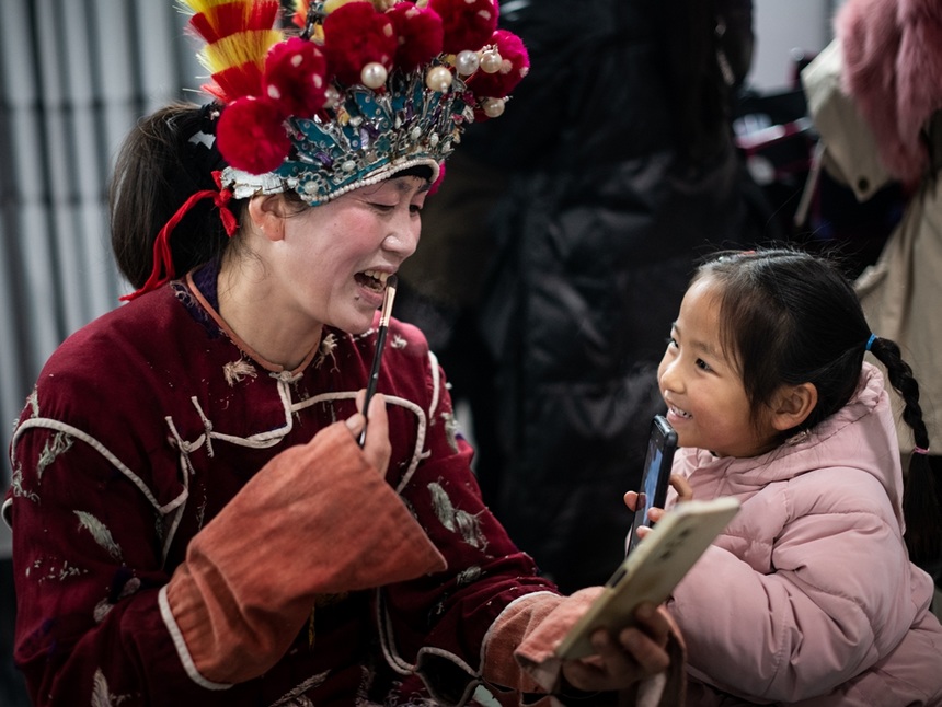 漢寨侗戲班演員與小孩互動。