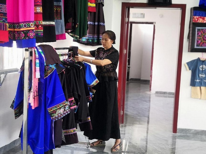 潘明飛整理民族服飾。受訪者供圖