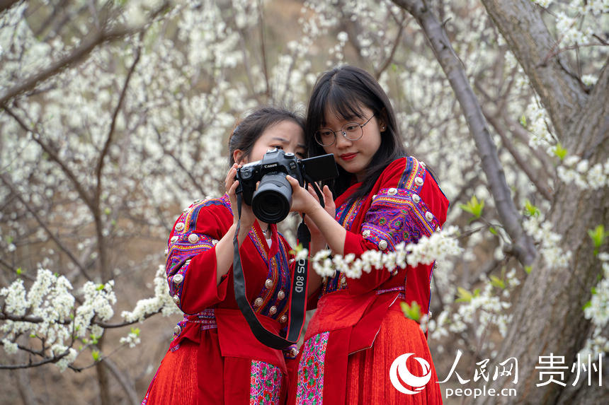 身著布依族服飾的游客正在拍攝照片。人民網 陽茜攝