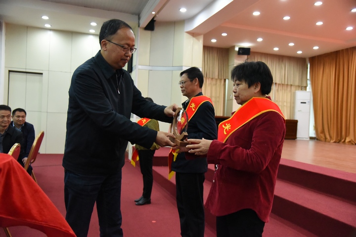 2 圖為冊亨縣委書記張茂同志為退休干部佩戴“光榮退休”綬帶并頒發紀念品。