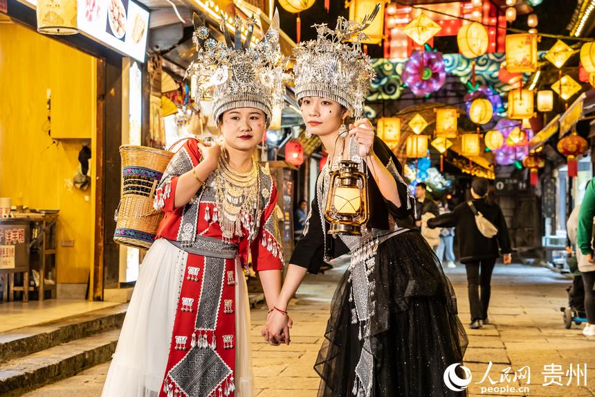 游客身著民族服飾站在古鎮街道上合影。人民網 陽茜攝