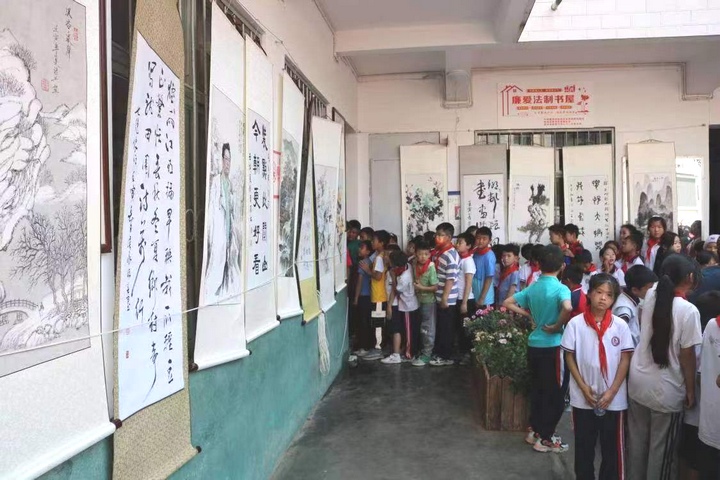 圖為黔西南州老年書畫研究會在興義市烏沙鎮中心小學開展“送書畫進校園”主題活動。