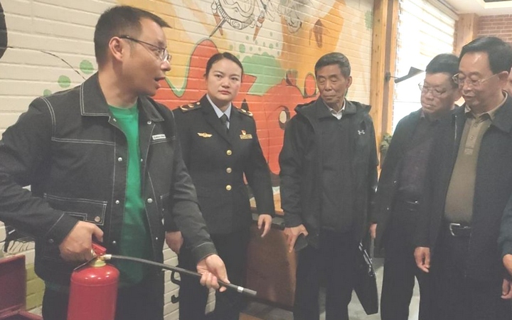 圖為網吧業主演示滅火器的使用。