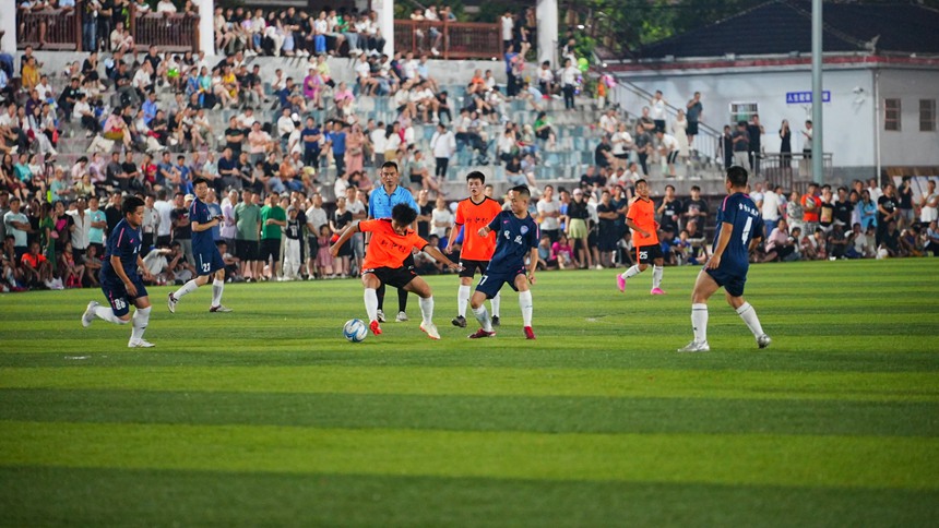 球員們在綠茵場上奮力踢球。周光勝攝