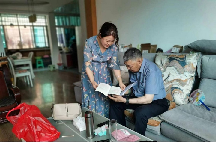 2 圖為為退休干部朱達昌送“學習包”并解讀政策、答疑解惑。