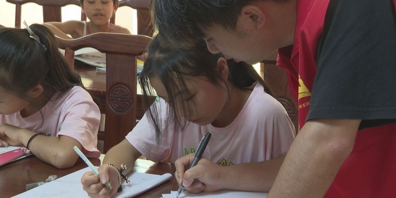 志愿者在輔導孩子作業 郭振東攝.jpg