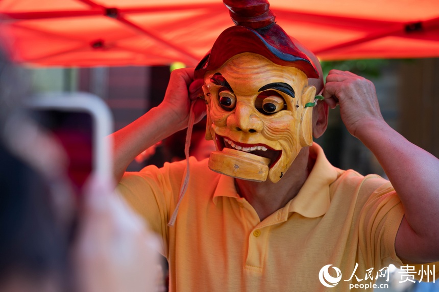 游客試戴儺戲面具。人民網 陽茜攝