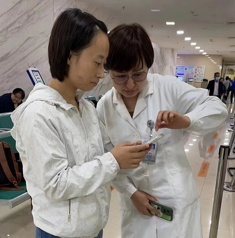 工作人員教患者體驗門診慢特病網上申報。貴州醫科大學附屬醫院供圖