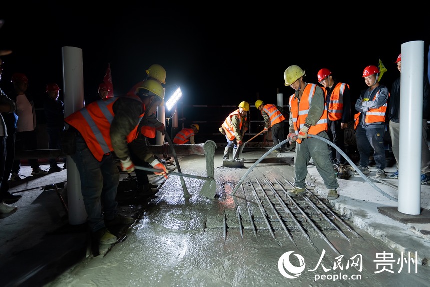 工人正在進行合龍段混凝土澆筑施工。人民網記者 涂敏攝