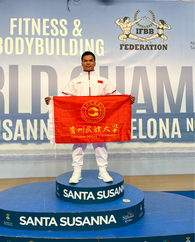 2 李科廷手持貴州民族大學校旗在2023年全國健美錦標賽現場合影。