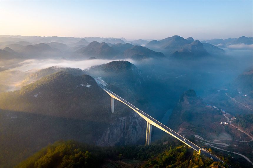 11月28日清晨，貴畢公路六廣河特大橋與云海、山川交相輝映，構成一幅壯美的交通畫卷。