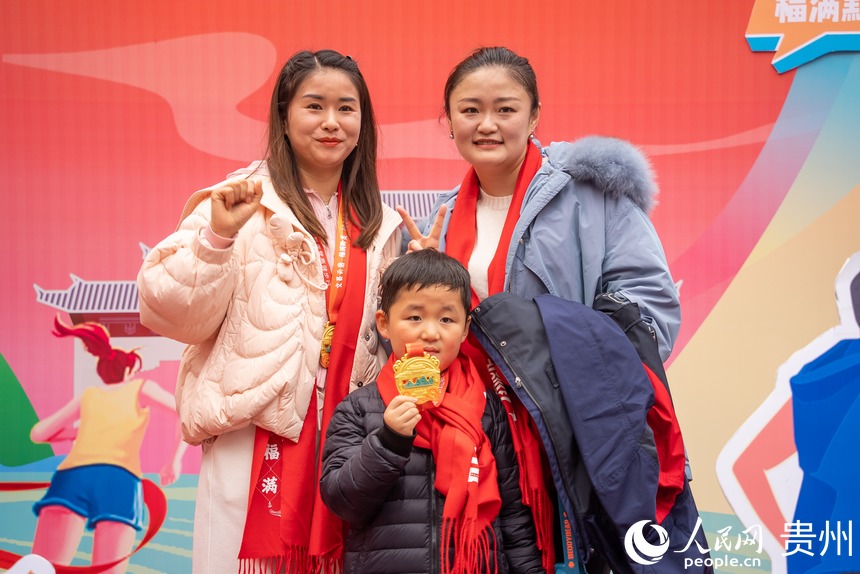 參與貴陽貴安第53屆全民健身登高迎新跑的市民在終點打卡拍照。人民網記者 涂敏攝