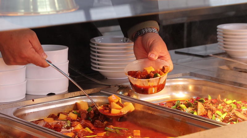 (4)食堂工作人員正在給顧客盛菜(王磊 攝).bmp