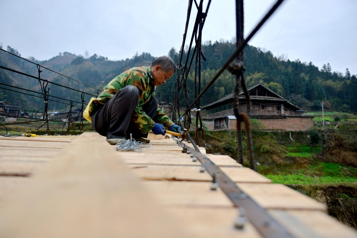 村民在修繕吊橋。胡濤攝