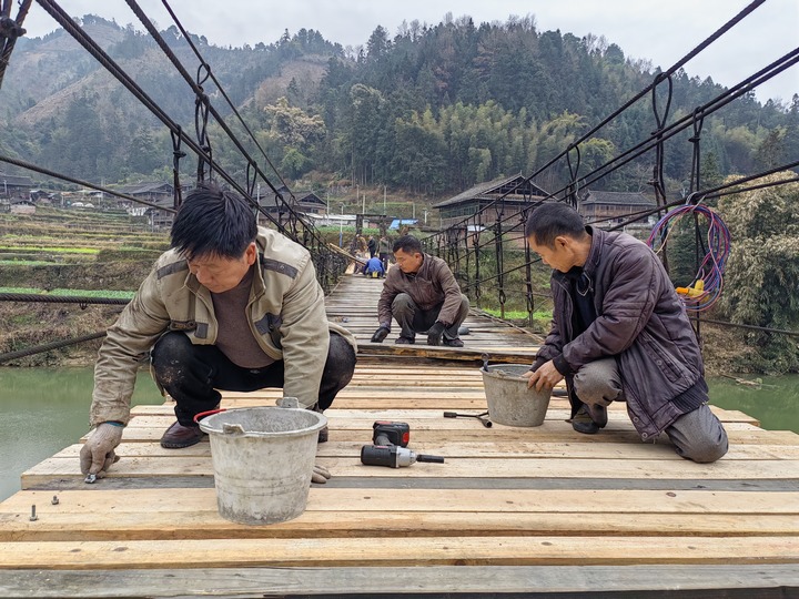 村民在修繕吊橋。董林丹攝