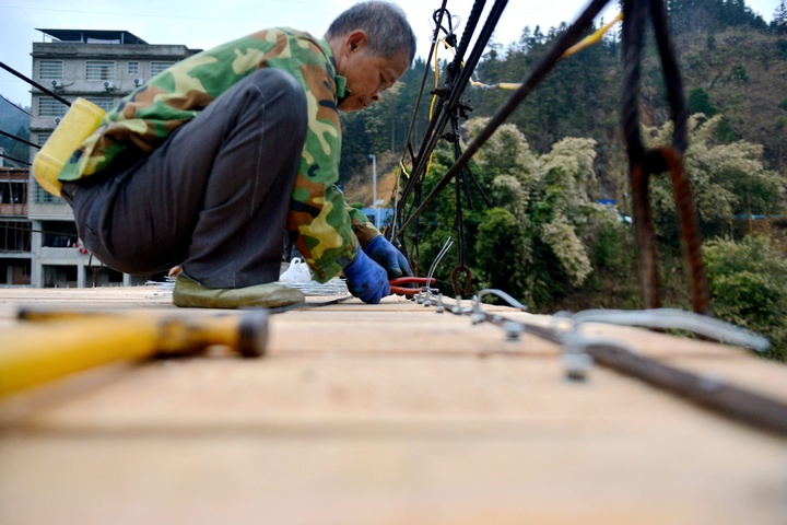 村民在修繕吊橋。胡濤攝