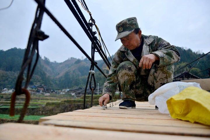 村民在修繕吊橋。胡濤攝