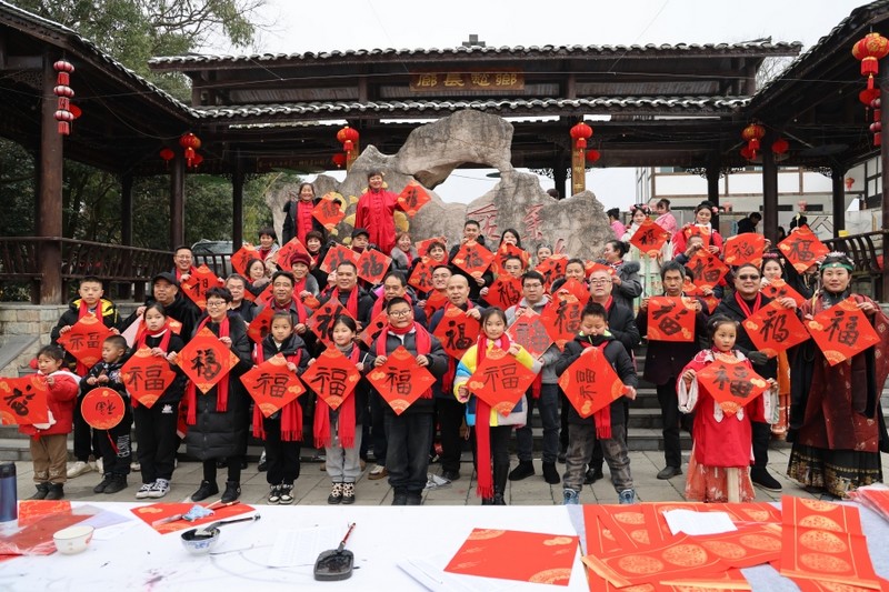 一副副大紅的春聯和數百個“?！弊执阂馀?、翰墨飄香，寄托著書法家們的美好祝福，不斷傳遞到群眾手中。姜繼恒 攝.jpg