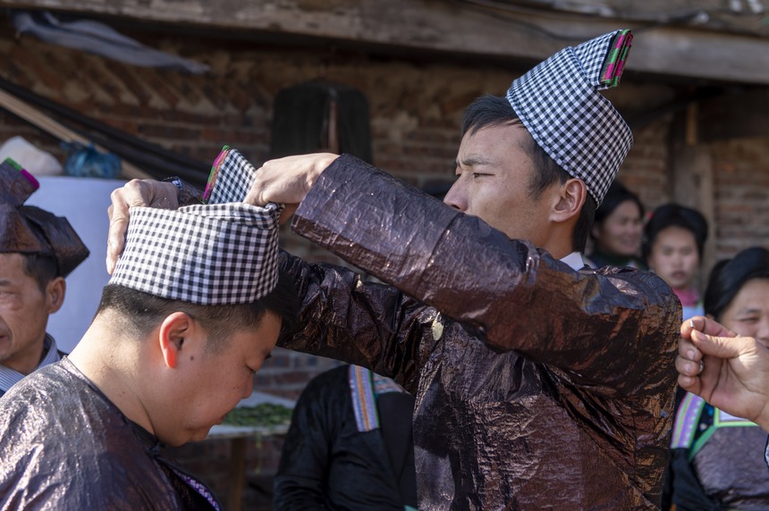 2024年2月11日，在貴州省從江縣丙妹鎮大塘村，苗族舅舅在整理包頭帕準備給外甥女送“年粑”。