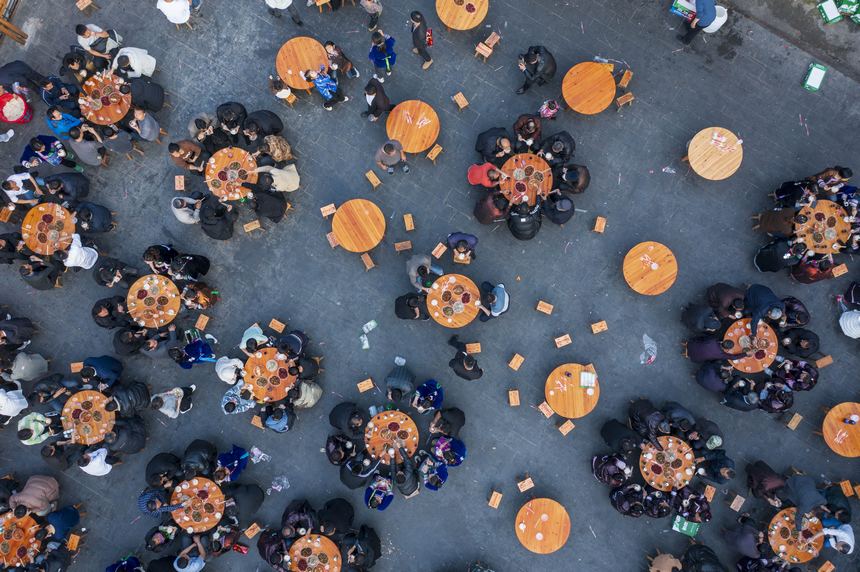 貴州省從江縣往洞鎮增沖村，當地侗族同胞與來自該縣停洞鎮架里村的苗族同胞在鼓樓旁的院壩吃晚飯（無人機照片）