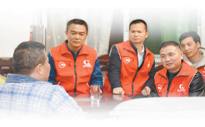 游德祥（右二）和志愿者一起走訪困難司機。吳 杰攝