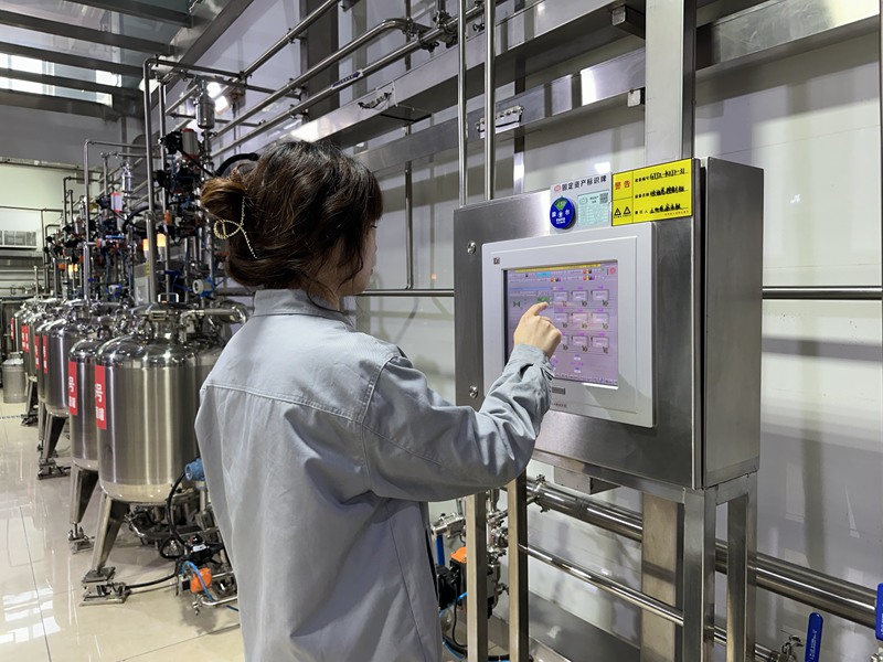 制酒車間工作人員正操縱儀器檢查酒質