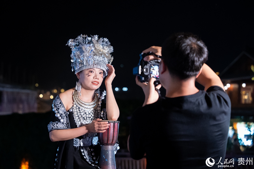 游客身著苗族特色服飾在景區內打卡拍照。人民網記者 涂敏攝