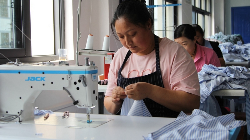 一塊塊裁剪好的布料經過車間女工的巧手，變成了一件件精美的服裝 修文縣融媒體中心姜繼恒 攝