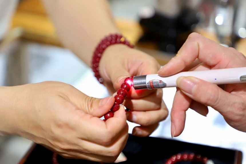 圖為工作人員檢驗朱砂手串品質。 顧蘭云攝