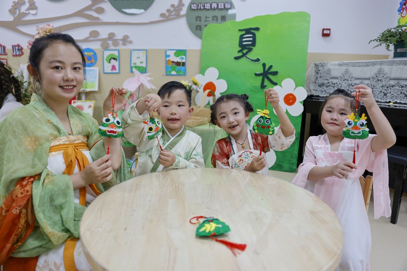 6月7日，在貴州省黔東南苗族侗族自治州施秉縣第四幼兒園，老師和小朋友展示剛做的香囊。磨桂賓攝