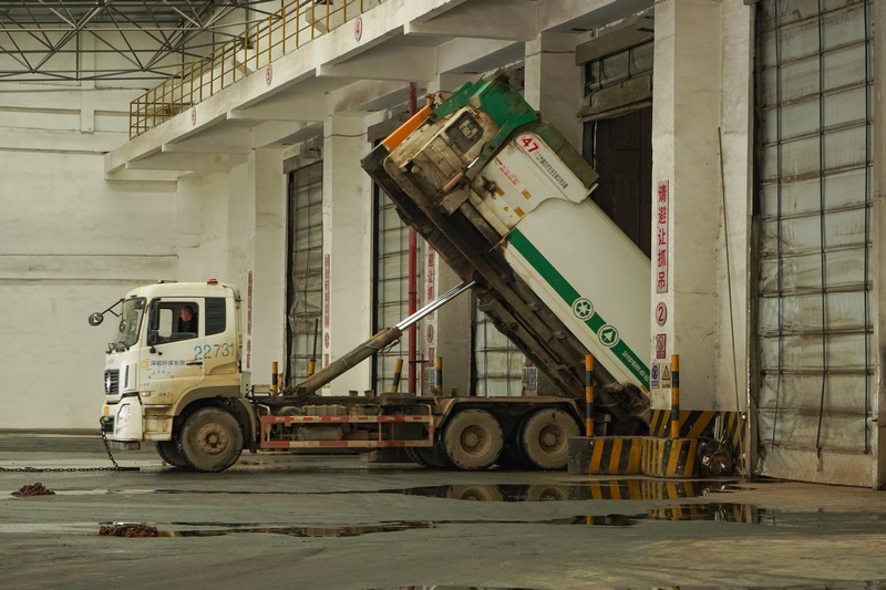 垃圾轉運車把收集的垃圾倒入垃圾發酵坑中。