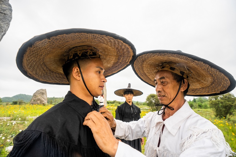 2024年7月5日，在貴州省畢節市百里杜鵑管理區方家坪景區，黃承龍正在為副祭司整理法衣。