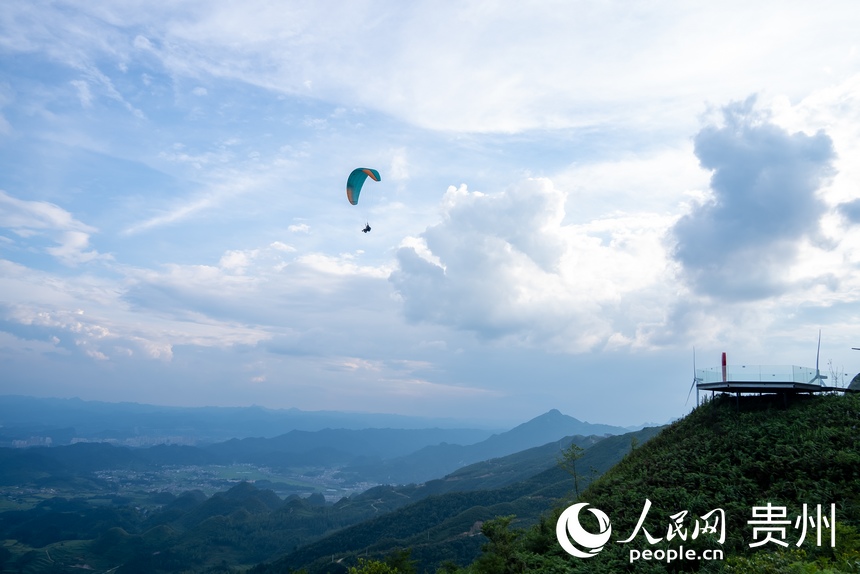 游客在玉簪花海中體驗滑翔傘。人民網記者 涂敏攝