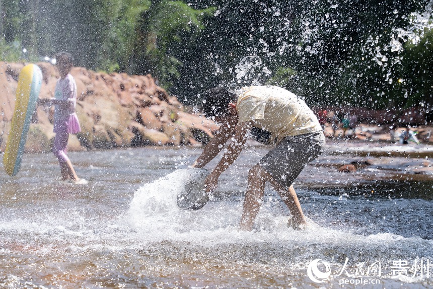 游客在瑪瑙灘內打水仗。人民網記者 涂敏攝
