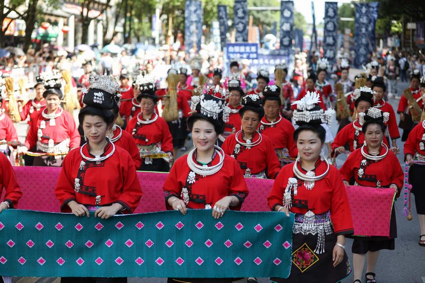 7月21日，貴州省丹寨縣身著傳統盛裝服飾的群眾，在展示國家級非遺項目苗族刺繡作品。