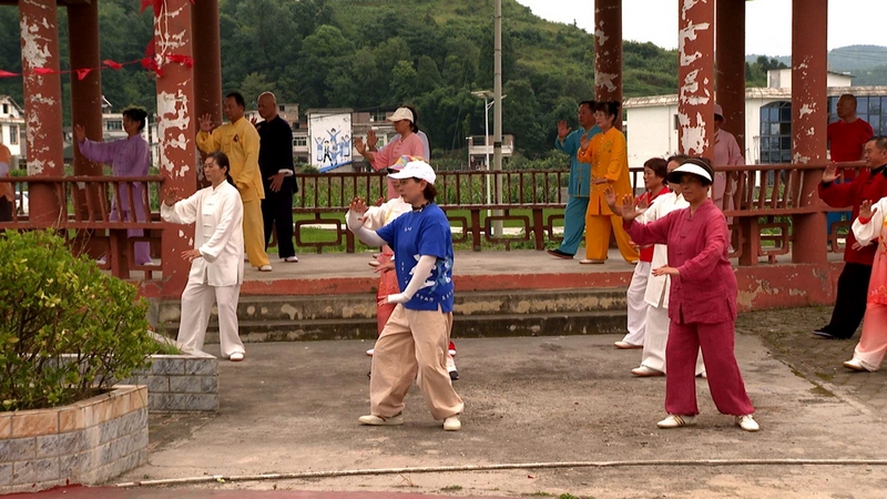 數十名游客迎著朝陽在村里的民族文化廣場上整齊劃一地練太極拳，盡情領略修文優美的生態環境和難得的清涼氣候 修文縣融媒體中心李云 攝