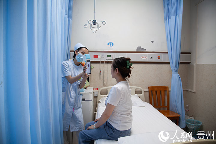 遵義市第一人民醫院胃腸外科病區，護士手持刷臉終端為王女士辦理出院結算。人民網記者 王秀芳攝