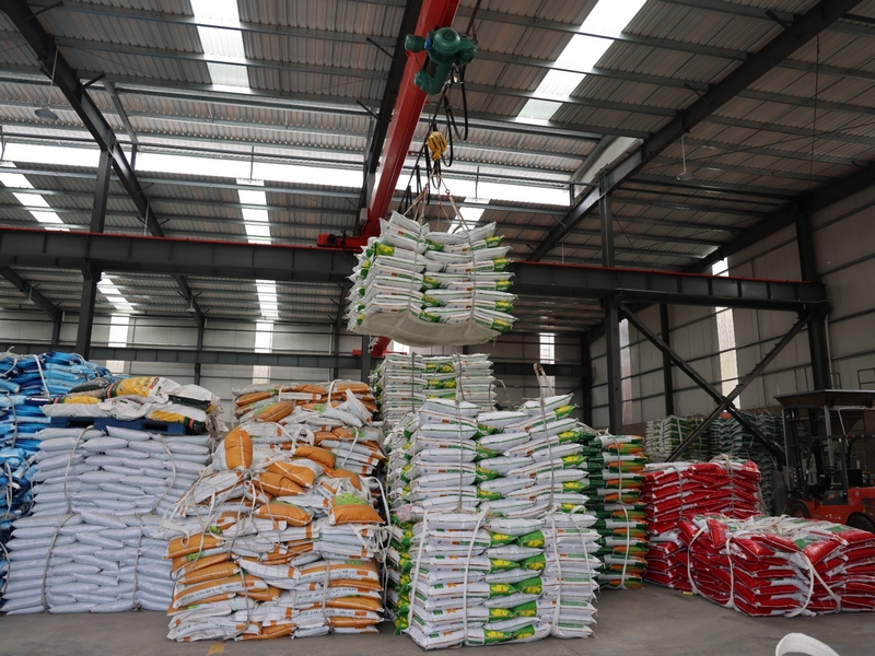 一袋袋包裝好的復合肥從傳送帶上快速運轉，被智能機械手臂抓取碼垛 修文縣融媒體中心李云 攝