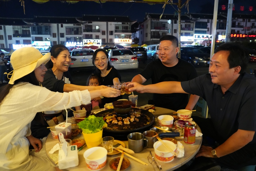 游客們舉杯共飲。段墨攝